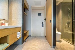 a bathroom with a shower and a sink and a toilet at City Comfort Inn Wuhan Dongxihu Tianyuan Avenue in Wuhan +49 photos