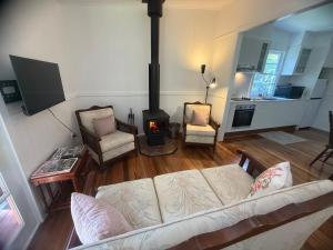 ein Wohnzimmer mit einem Sofa und einem Holzofen in der Unterkunft Martali Cottage in Wyberba