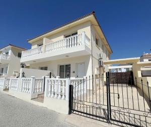 阿依纳帕Nissi Beach Golden Villas的一栋前面有栅栏的白色房子