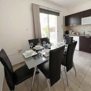 阿依纳帕Nissi Beach Golden Villas的一间有桌子和黑色椅子的餐厅