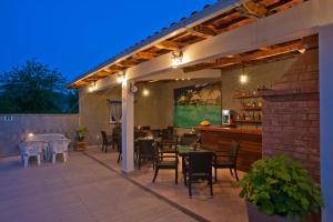 eine Terrasse mit Tischen und Stühlen sowie eine Bar in der Unterkunft Apartments Gold in Budva