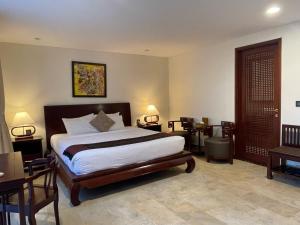 a bedroom with a bed and a table and chairs at Victoria Phan Thiet Beach Resort & Spa in Mui Ne