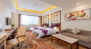 a hotel room with a bed and a couch at Sun City Hotel Haikou in Haikou