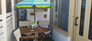 a small table with an umbrella on a balcony at Fay's House in Mesagrós