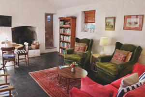 a living room with green furniture and a fireplace at The Snug in Robe