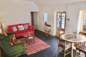 a living room with a red couch and a table at The Snug in Robe