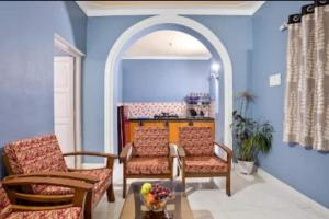 a living room with two chairs and a table at 5bhk Villa Near Caldolium Beach Goa in Candolim