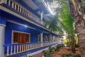 a blue house with a palm tree in front of it at 5bhk Villa Near Caldolium Beach Goa in Candolim