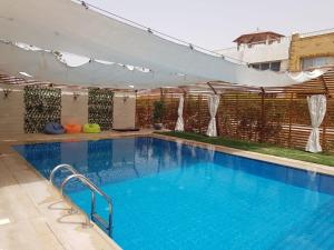 a large swimming pool with blue water at Shaleh Orkid 171 in Dawwār Shindī Fannūsh