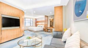 a living room with a couch and a tv at Horizon Hotel in Kunming