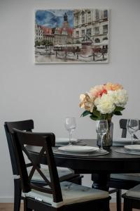 a dining room table with a vase of flowers on it at Spacious Apartment with WiFi & Smart TV Remote Working by Noclegi Renters in Wrocław