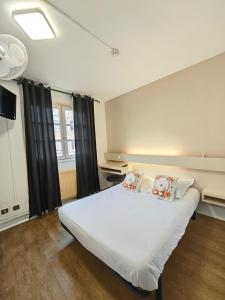 a bedroom with a large white bed with two pillows at La Route Des Vins in Belleville-en-Beaujolais