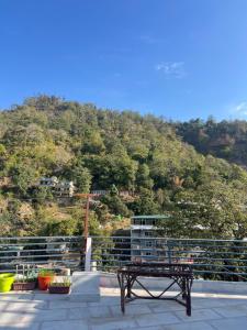 una panchina seduta in cima a un tetto con una montagna di Blissful homestay a Rishikesh