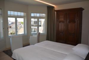 デ・パンネにあるVilla Anitaのベッドルーム1室(白いベッド1台、窓2つ付)