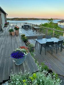 eine Terrasse mit einem Tisch, Stühlen und Blumen in der Unterkunft Cabin With Views And A Large Terrace In Søgne in Søgne + 30 Fotos