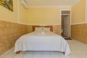 Funny Homestay 2 في غيلي تراوانغان: غرفة نوم بها سرير أبيض في الغرفة