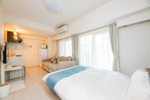 a bedroom with a white bed and a couch at Presence Hakata in Fukuoka +27 photos