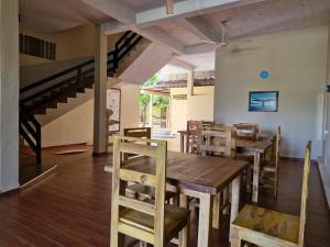 a restaurant with wooden tables and chairs and a staircase at Royal Point Arugambay in Arugam Bay
