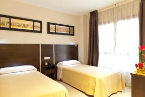 מיטה או מיטות בחדר ב-Hostal Avenida Barajas