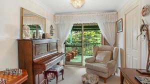 sala de estar con piano y silla en Blue Mountains National Park Valley Views, en Wentworth Falls