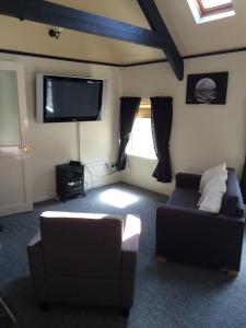 a living room with two couches and a flat screen tv at Hardwick Hotel in Horden