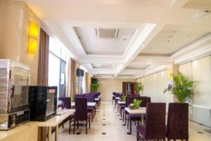 ein Esszimmer mit Tischen und lila Stühlen in der Unterkunft GreenTree Inn Jiangsu Wuxi Xishan DongTing Erquan East Road XinGuang Newly Estate Express Hotel in Wuxi