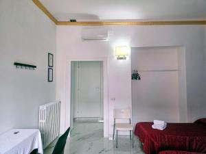 ein weißes Zimmer mit einem Bett, einem Tisch und einem Stuhl in der Unterkunft Relax ON 247 in Rom