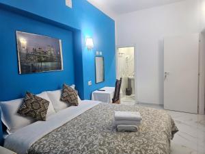 ein blaues Schlafzimmer mit einem großen Bett, auf dem Handtücher liegen in der Unterkunft Relax ON 247 in Rom