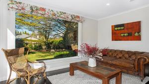 a living room with a couch and a window at Glenluce Mountain Cottage Circa 1896 in Wentworth Falls