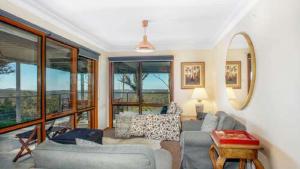 a living room with a couch and chairs and windows at Hat Hill Hideaway Amazing Valley Views in Blackheath