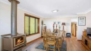 a dining room with a table and a wood stove at Hat Hill Hideaway Amazing Valley Views in Blackheath