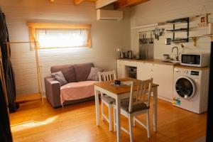 a living room with a table and a couch and a kitchen at Kapok Pod entire studio in Horseshoe Bay
