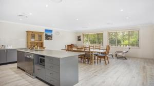 a kitchen and dining room with a table and chairs at Refresham Katoomba South in Katoomba +8 photos