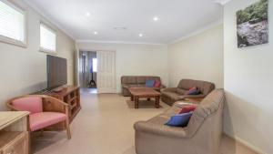 a living room with a couch and a tv at Refresham Katoomba South in Katoomba