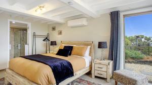 Un dormitorio con una cama y una ventana grande. en Donlen Cottage Wentworth Falls 180 Degree Views, en Wentworth Falls