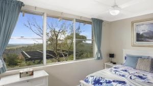 Un dormitorio con una cama y una ventana grande. en Donlen Cottage Wentworth Falls 180 Degree Views, en Wentworth Falls 16 fotos más