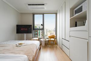 Un dormitorio con una cama y una ventana grande. en Urbanstay Myeongdong, en Seúl