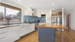 Una cocina con gabinetes blancos y una ventana grande. en Bella Vista Valley Views, en Blackheath
