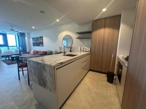 a kitchen with a counter with a sink and a living room at Queens Wharf Diamond Level 60, Sleep 5, 1 carpark in Brisbane