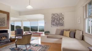 a living room with a couch and a fireplace at Cecils Chair Blackheath Blue Mountains in Blackheath