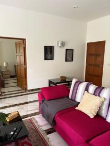 a living room with a pink couch and a table at Hua Hin in Hua Hin