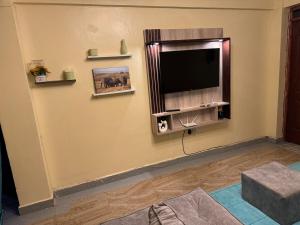 a living room with a flat screen tv on a wall at Luxury-Inn Apartment in Nyeri