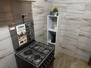 a small kitchen with a stove in a room at Luxury-Inn Apartment in Nyeri