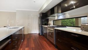 a large kitchen with wooden floors and stainless steel appliances at The Cherry Blossom Blackheath in Blackheath +11 photos