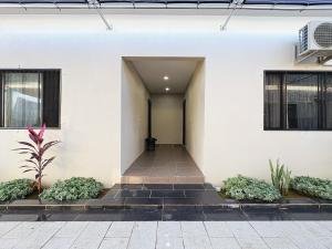 a hallway of a white building with plants at Nadi Vivi Apartments in Nadi