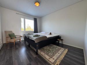 a bedroom with a bed and a window and a rug at Anolanranta Beach House - Golf & Lake in Pieksamaki +67 photos