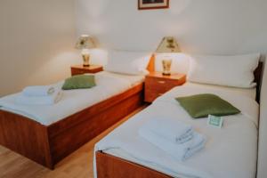 two twin beds in a room with two lamps at The Rooms by Dalia in Košice