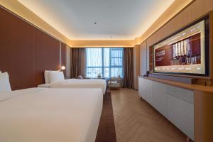 a hotel room with two beds and a flat screen tv at Yangjiang Jiangcheng Jinshang Road Orange Crystal Hotel in Yangjiang +43 photos