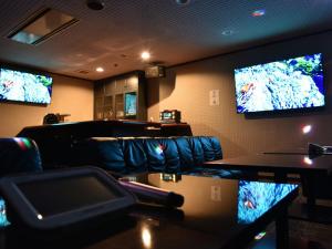 un bar con tre televisori sul muro e sedie di 貸切宿さうなす a Nasushiobara