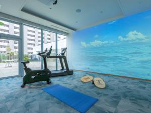 a gym with a fitness room with the ocean at Tokyu Stay Okinawa Naha in Naha